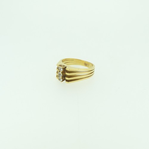 318 - A yellow gold Ring, with split reeded shoulders, the front vertically set three white pastes, tests ... 