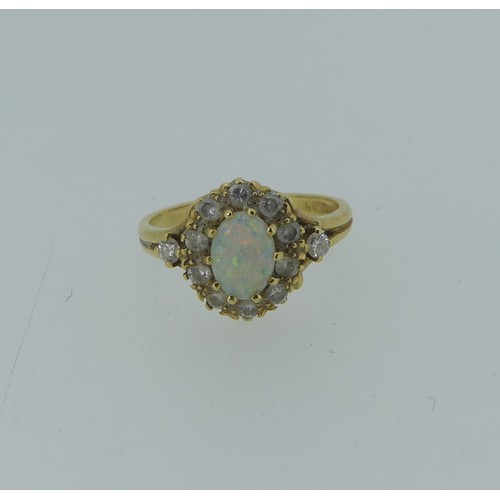 336 - An opal and diamond cluster Ring,the oval central opal approx. 7.1mm long, with ten diamonds around ... 