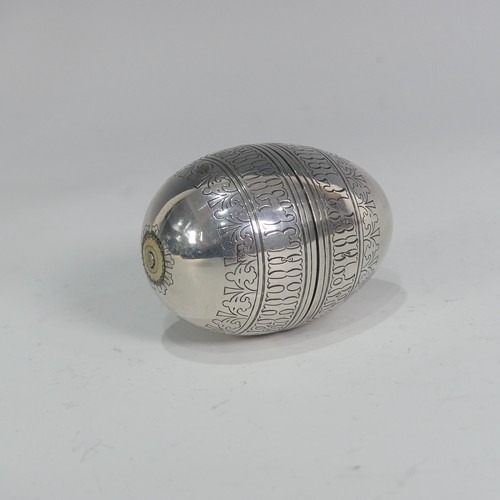 A Russian silver Travelling Egg Cup, in the form of an egg that pulls apart with each half having a screw fitting pedestal foot inside, engraved Cyrillic and geometric decoration, each cup 6cm high, the egg closed 6.3cm long, 2.9ozt, marks worn.