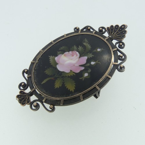 473 - A Pietra Dura Memorial Brooch, the oval panel with pink rose, in unmarked white metal framework moun... 