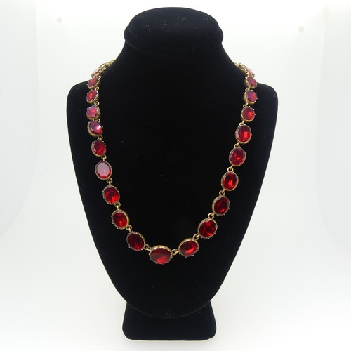 358 - An antique graduated red paste Necklace, the oval facetted stone in closed back gilt metal mounts wi... 