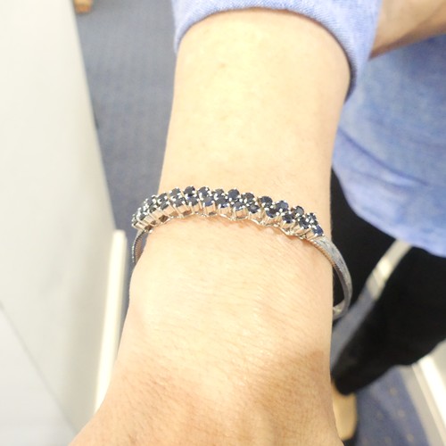 410 - A 9ct white gold mesh Bracelet, the front claw set with two rows of circular sapphires, marked 375 o... 