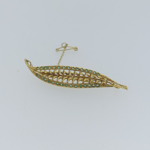 448 - A 9ct yellow gold Leaf Brooch, pierced and with two rows of small emeralds, 7cm long, approc weight ... 