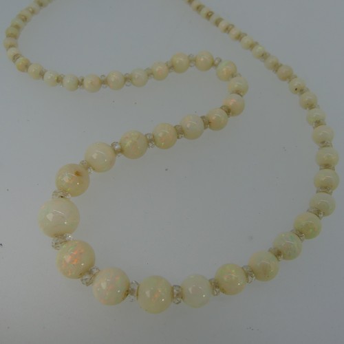 379 - A graduated opal bead Necklace, the white opals with facetted rock crystal spacers between each bead... 