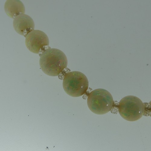 379 - A graduated opal bead Necklace, the white opals with facetted rock crystal spacers between each bead... 