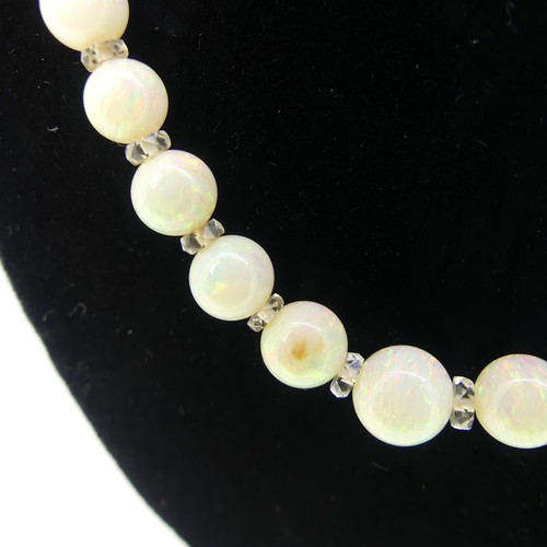 379 - A graduated opal bead Necklace, the white opals with facetted rock crystal spacers between each bead... 