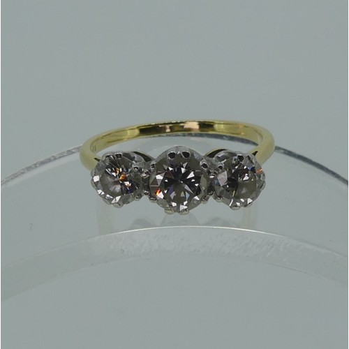 326 - A three stone diamond Ring, the centre circular stone approx 0.63ct, with a smaller stone one either... 