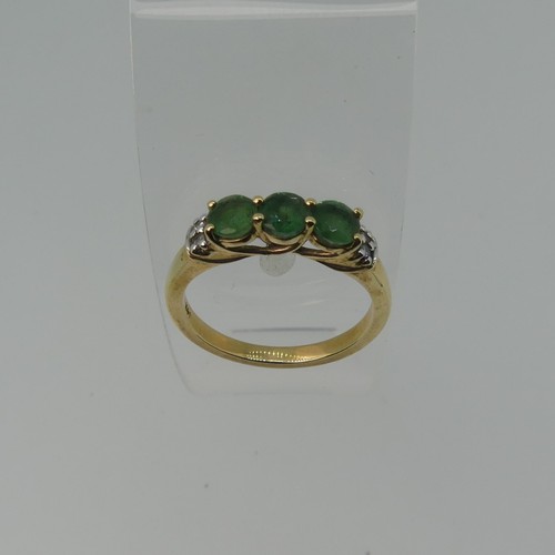 343 - A three stone emerald Ring, the circular facetted stones approx 4.4mm diameter, with two diamond poi... 