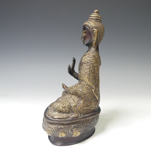 219 - An antique Sino-Tibetan gilt bronze figure of the Buddha, seated in dhyanasana on a lotus base, wear... 