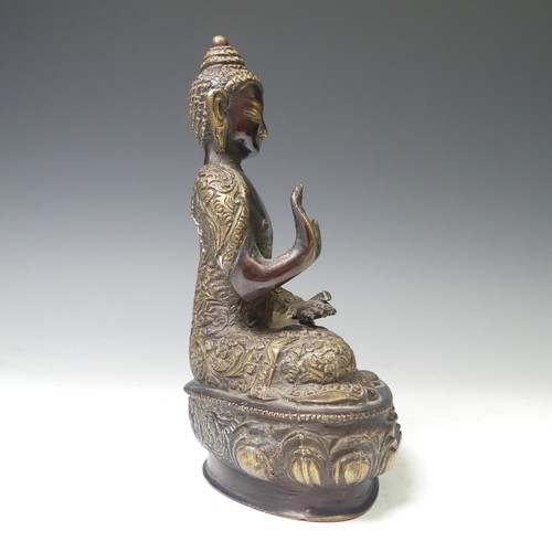 219 - An antique Sino-Tibetan gilt bronze figure of the Buddha, seated in dhyanasana on a lotus base, wear... 