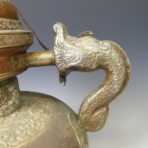 224 - A large Tibetan copper Tea Pot, with white metal mounts, the handle and spout modelled as a mythical... 