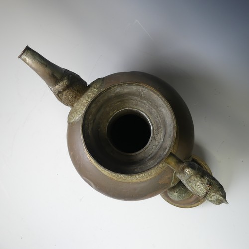 224 - A large Tibetan copper Tea Pot, with white metal mounts, the handle and spout modelled as a mythical... 