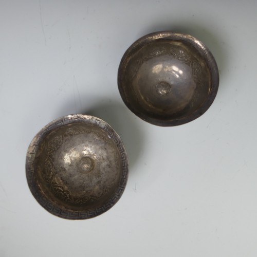 226 - A pair of Eastern circular silver Bowls, probably Tibetan, decorated with Buddhist symbolism and Gre... 