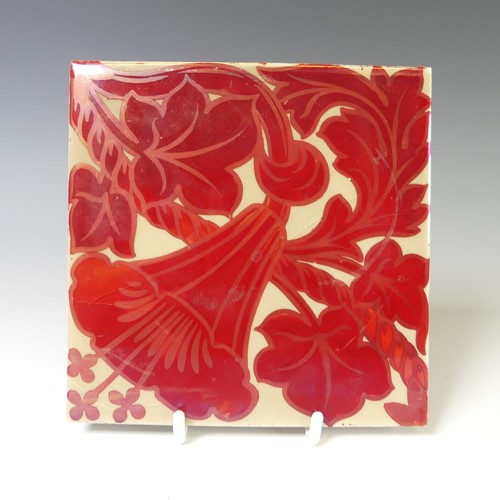 130 - A 20thC pottery Tile, in the style of William de Morgan, the cream ground with ruby lustre floral de... 