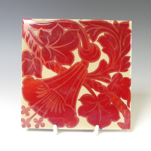 130 - A 20thC pottery Tile, in the style of William de Morgan, the cream ground with ruby lustre floral de... 