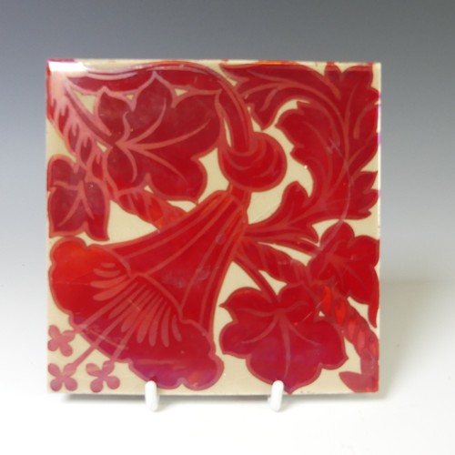 130 - A 20thC pottery Tile, in the style of William de Morgan, the cream ground with ruby lustre floral de... 