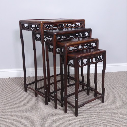 254 - An early 20thC Chinese hardwood quartetto nest of Tables, panelled tops above carved and pierced fri... 