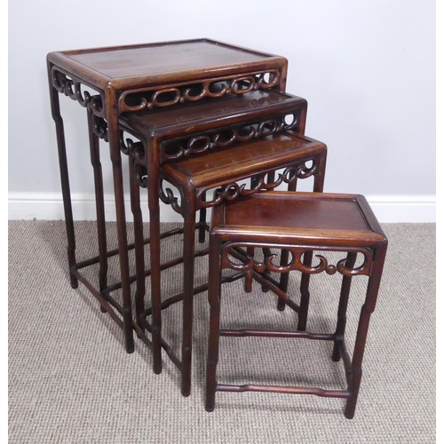 254 - An early 20thC Chinese hardwood quartetto nest of Tables, panelled tops above carved and pierced fri... 