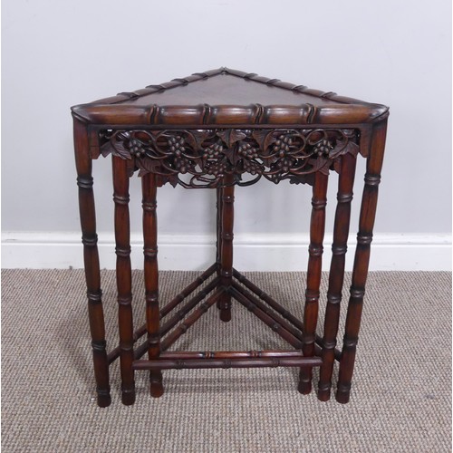 255 - An unusual Chinese hardwood triangular nest of three Tables, frieze carved and pierced with grapes a... 