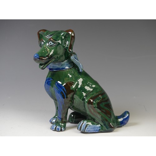 171 - An early 20thC C. H. Brannam glazed figure of a Dog, of green ground, modelled with collar and spots... 