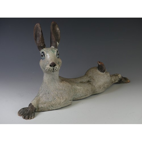 136 - A studio pottery raku Hare, in the style of Lawson Rudge, modelled in recumbent pose with crossed fr... 