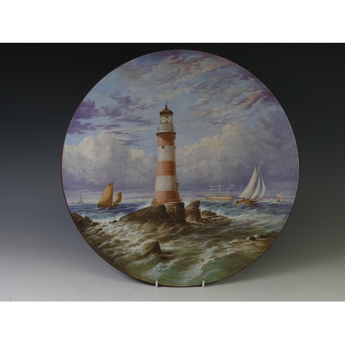 147 - A late 19thC enamelled and painted Charger, depicting a lighthouse before stormy seas, signed A Fish... 