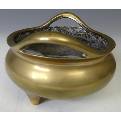 217 - A Chinese gilt bronze Tripod Censer, of typical circular form with two loop handles, raised on three... 