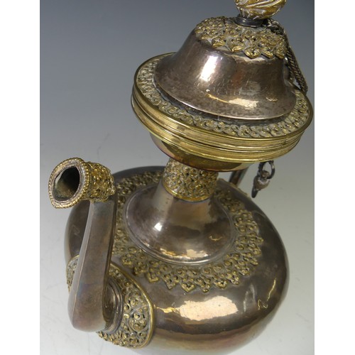 222 - A 19thC Tibetan silver and parcel-gilt ceremonial Teapot / Ewer, the plain tapering circular body wi... 