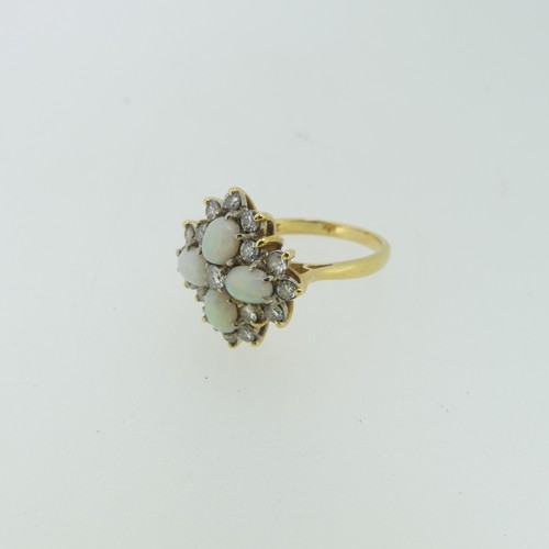 99 - An opal and diamond cocktail Ring, with four oval cabochon opals, each 5.5mm long, set in a cross wi... 