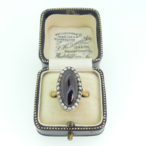 103 - An early 19thC garnet and seed pearl cluster Ring, the oval cabochon garnet 20mm long, with seed pea... 