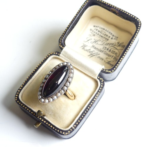 103 - An early 19thC garnet and seed pearl cluster Ring, the oval cabochon garnet 20mm long, with seed pea... 