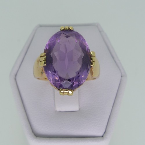 106 - An amethyst Dress Ring, the oval facetted stone 15mm long, mounted in 18ct yellow gold, Size M, 7.7g... 