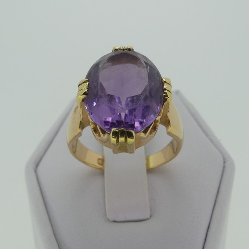 106 - An amethyst Dress Ring, the oval facetted stone 15mm long, mounted in 18ct yellow gold, Size M, 7.7g... 