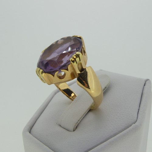 106 - An amethyst Dress Ring, the oval facetted stone 15mm long, mounted in 18ct yellow gold, Size M, 7.7g... 