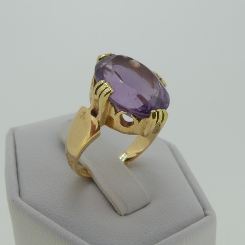 106 - An amethyst Dress Ring, the oval facetted stone 15mm long, mounted in 18ct yellow gold, Size M, 7.7g... 