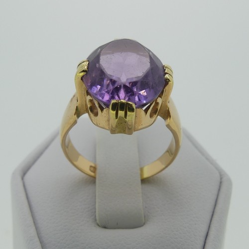 106 - An amethyst Dress Ring, the oval facetted stone 15mm long, mounted in 18ct yellow gold, Size M, 7.7g... 