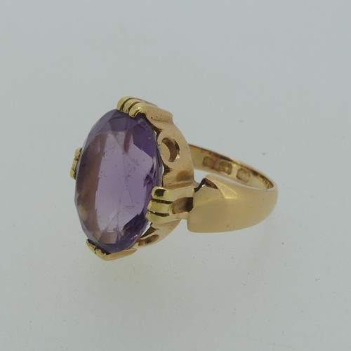 106 - An amethyst Dress Ring, the oval facetted stone 15mm long, mounted in 18ct yellow gold, Size M, 7.7g... 