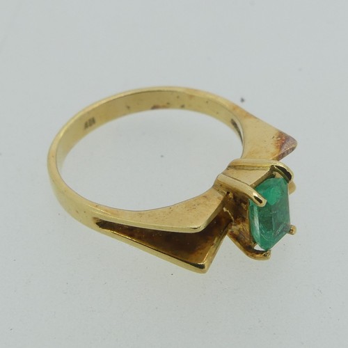 107 - A small emerald Ring, the emerald cut stone 5.9mm long, four claw set in a modernist 18ct gold shank... 