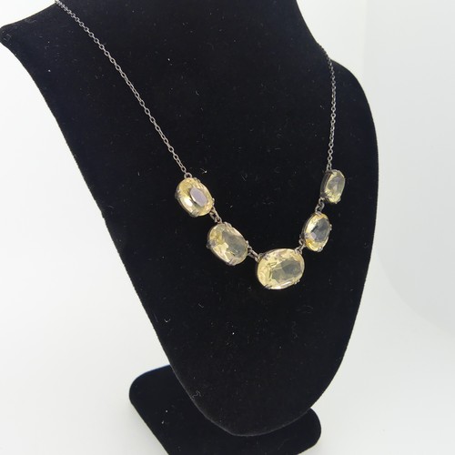 151 - A vintage graduated five stone citrine Necklace, the oval facetted stones claw set on integral silve... 