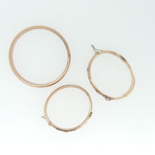 230 - Two 9ct rose gold hollow hinged Buckle Bangles, as found, together with a plain 9ct rose gold hollow... 