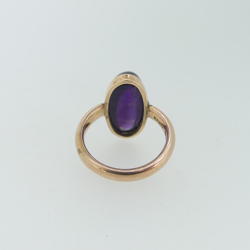 110 - An oval cabochon amethyst Ring, 2cm long, mounted in 9ct rose gold, Size M, 7.2g.