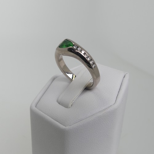 115 - A modernist tsavorite and diamond Ring, the trilliant cut stone approx 4.6mm long, collet set with s... 