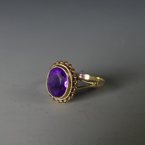 234 - A 9ct yellow gold and amethyst Ring, the oval facetted stone 9.5mm long, in a ropetwist mount, Size ... 