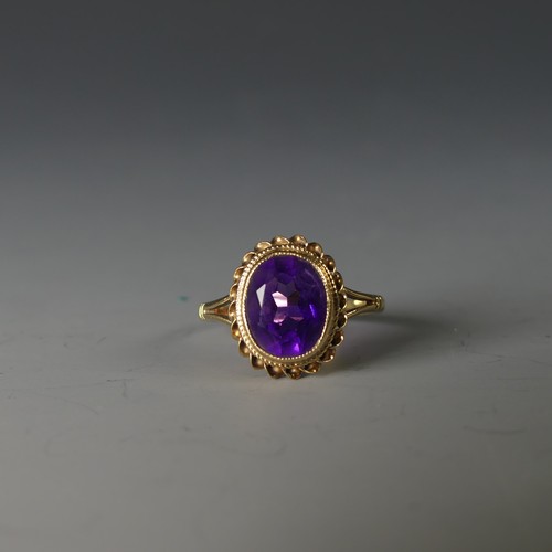 234 - A 9ct yellow gold and amethyst Ring, the oval facetted stone 9.5mm long, in a ropetwist mount, Size ... 