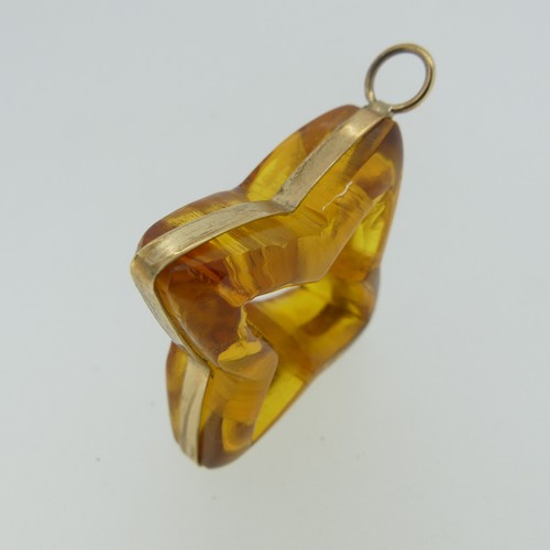 237 - A gold mounted carved amber 'Star' Pendant, 4cm wide, unmarked, tests as 9ct, in accompanying box an... 