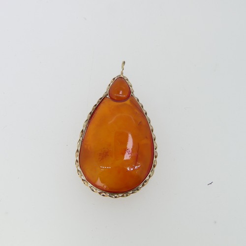 238 - A Persian amber Ring, in unmarked ropetwist border and plain shank, tested as 9ct gold, the amber 2.... 