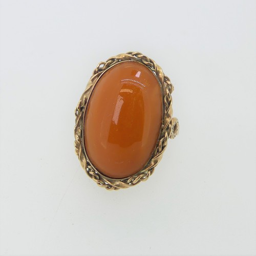 238 - A Persian amber Ring, in unmarked ropetwist border and plain shank, tested as 9ct gold, the amber 2.... 