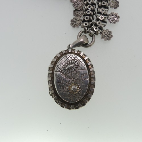 162 - A Victorian silver Locket and Chain, in the Aesthetic style, the oval hinged locket with foliate dec... 