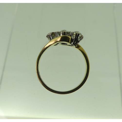 119 - A graduated three stone diamond Ring, the circular stones set on the cross on a plain 18ct gold shan... 