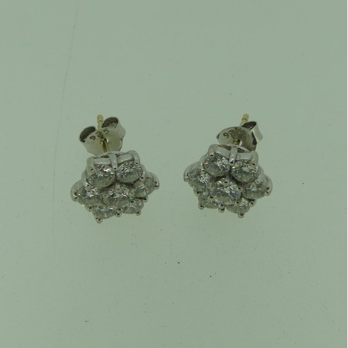 206 - A pair of diamond flowerhead cluster Earrings, the central circular diamond approx 0.17ct, claw set ... 